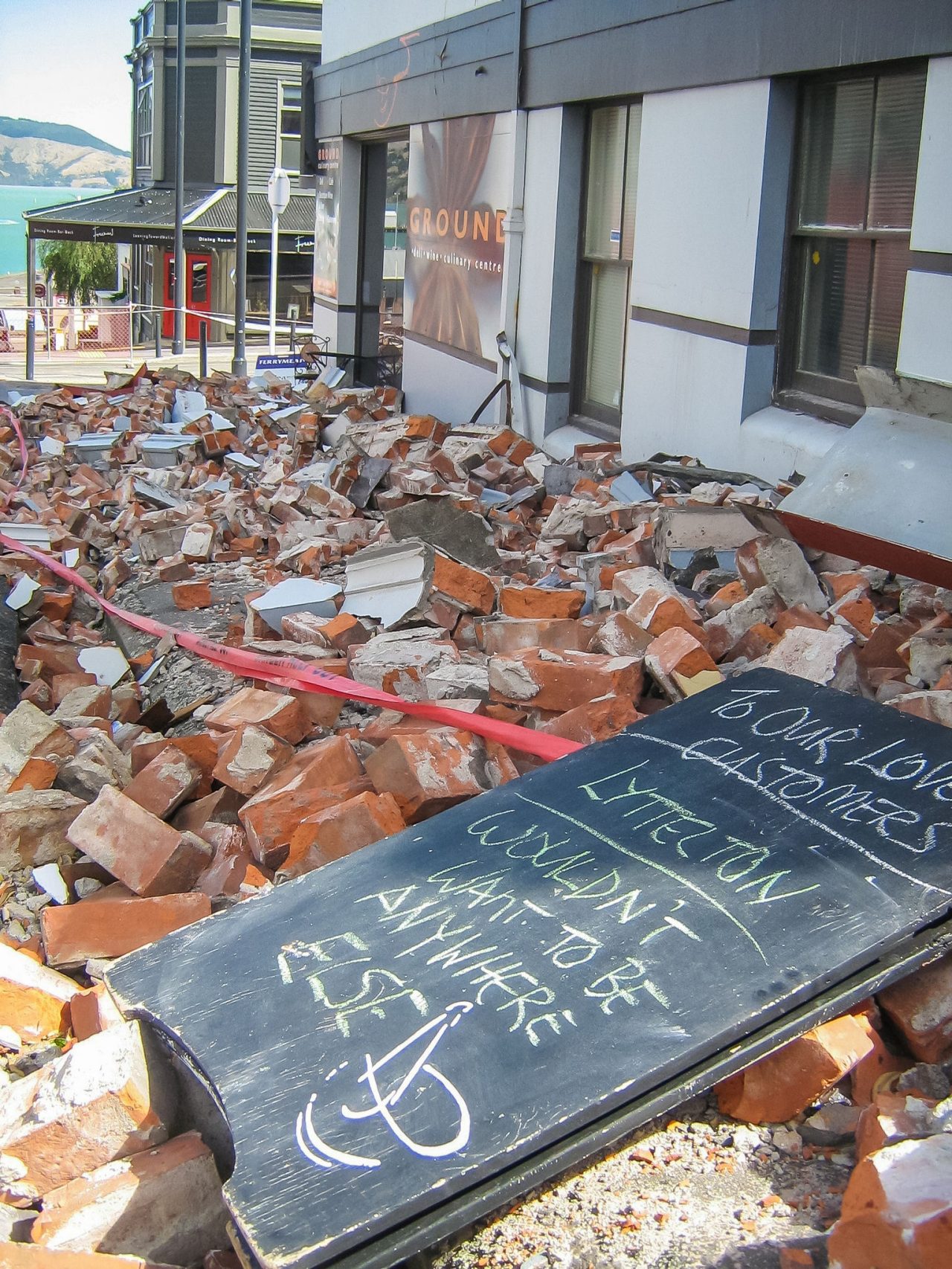 cafe sign amongst fallen bricks