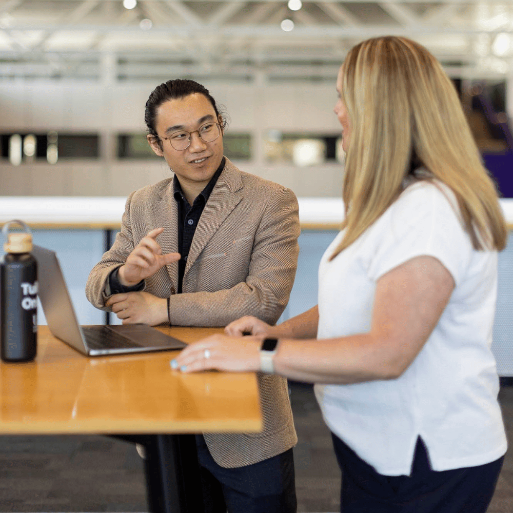 Two learners discussing agile project management methodology in their postgraduate project management course.