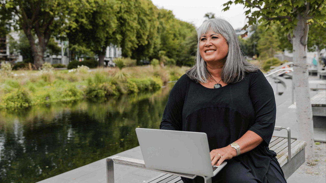 Woman studying towards her Master of Sustainable Futures and Innovation outside, learning with Tuihono UC | UC Online