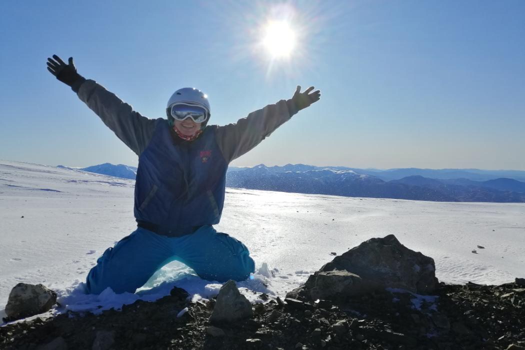 A UC student kneeling in the snow on Mt Cook.