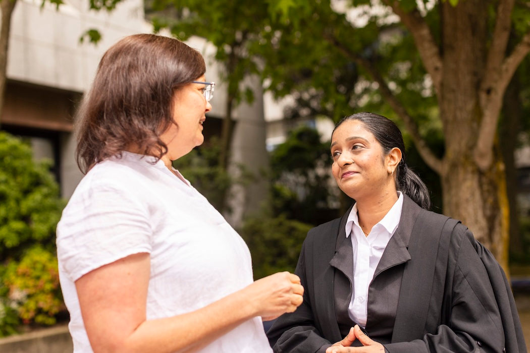 UC Law student and staff member talking