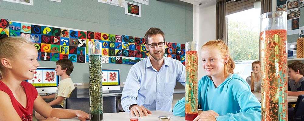 Primary teacher and students viewing science experiments
