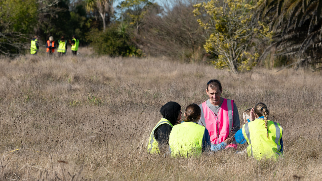 Students sampling soil for microbes in the red zone