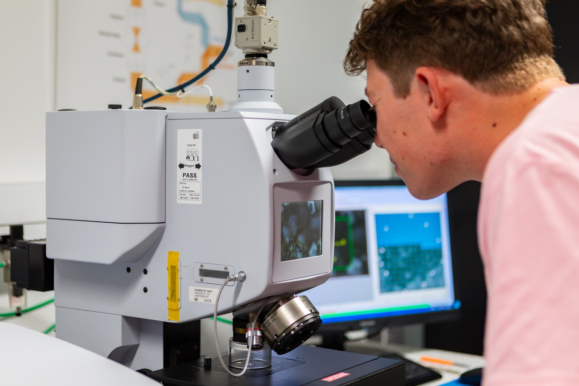 Researcher looking into a Microscope Fourier Transform Infared Microscope