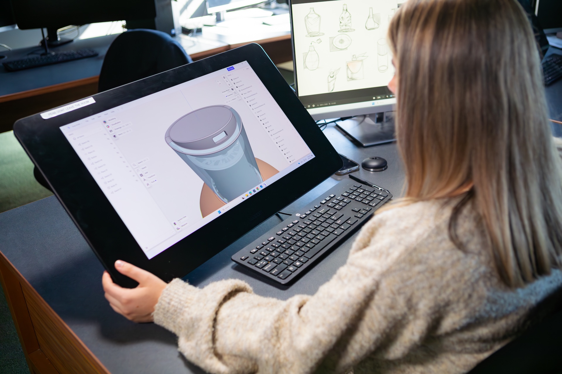 Researcher viewing a screen showing a 3d model.