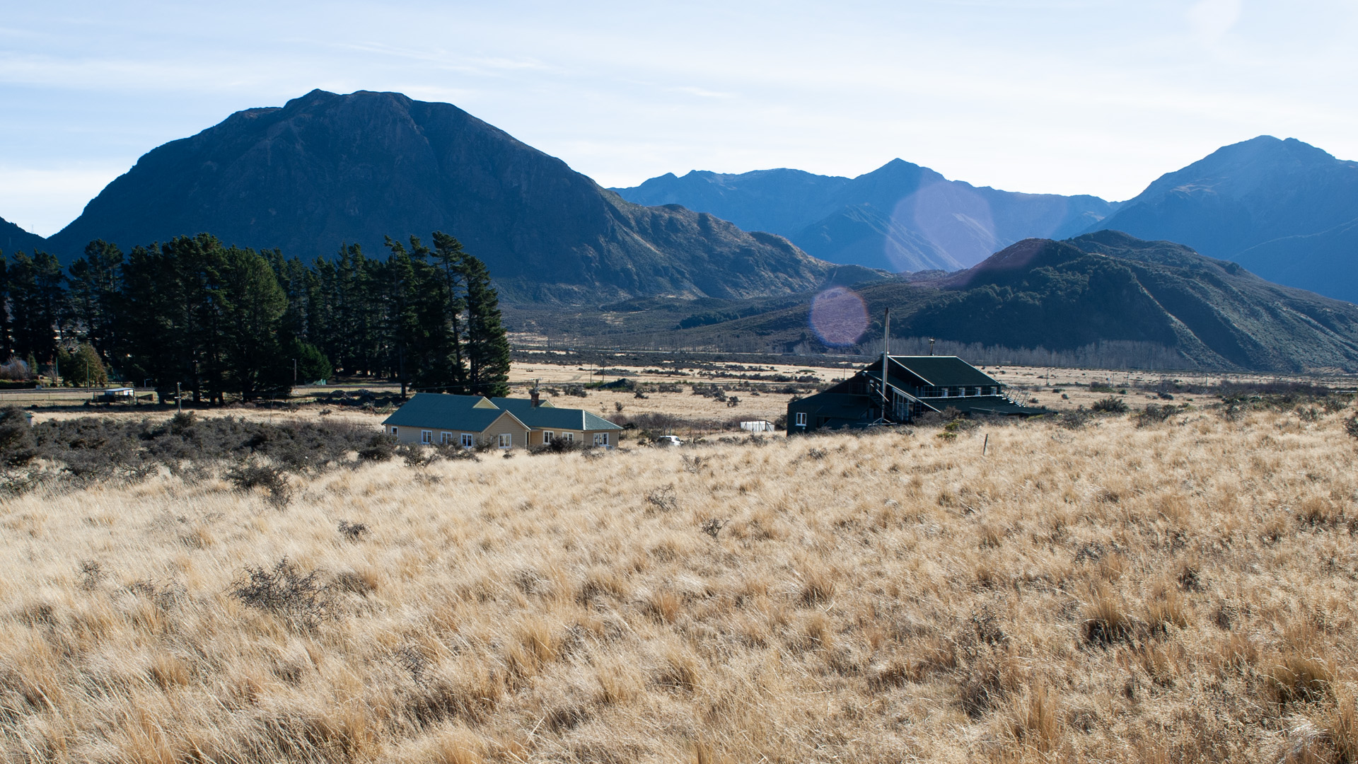 Cass field station building surrounded by grasslands, with mountains in the distance.
