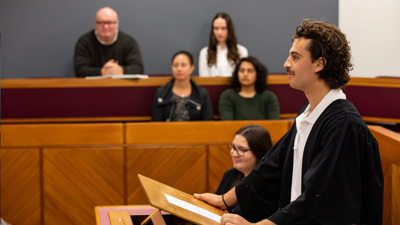 UC Law student speaking at a lectern