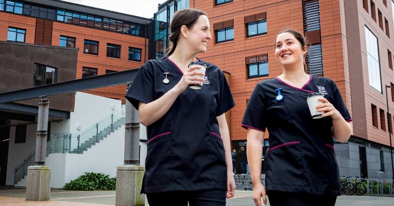 Two student nurses walking outside of campus