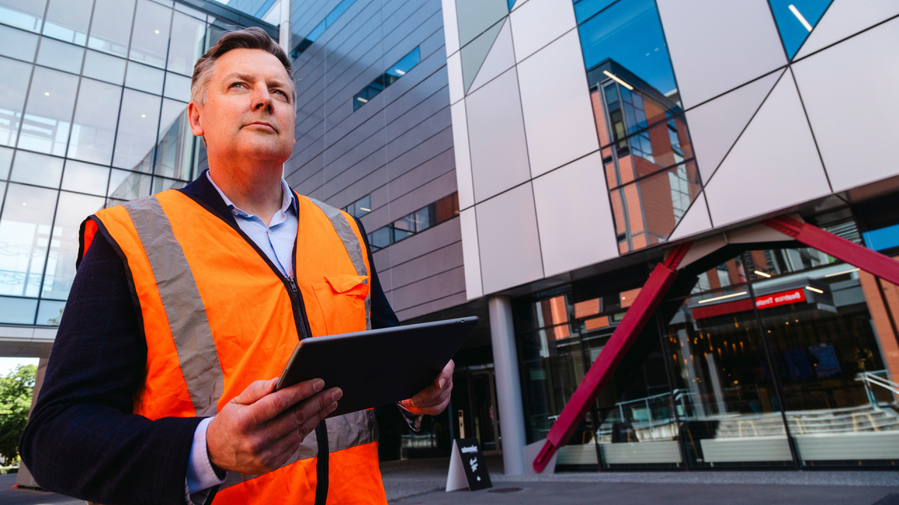 Man in hi-vis evaluating disaster risk after studying disaster law online. 
