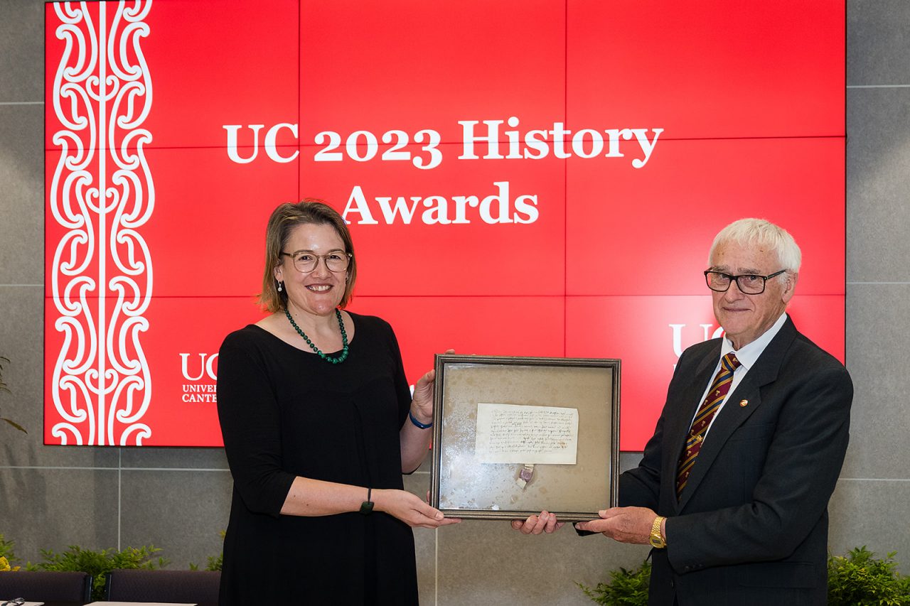 Emeritus Professor Geoff Rice presents the manuscript to Macmillan Brown Library manager Fiona Tyson at the 2023 UC History Awards