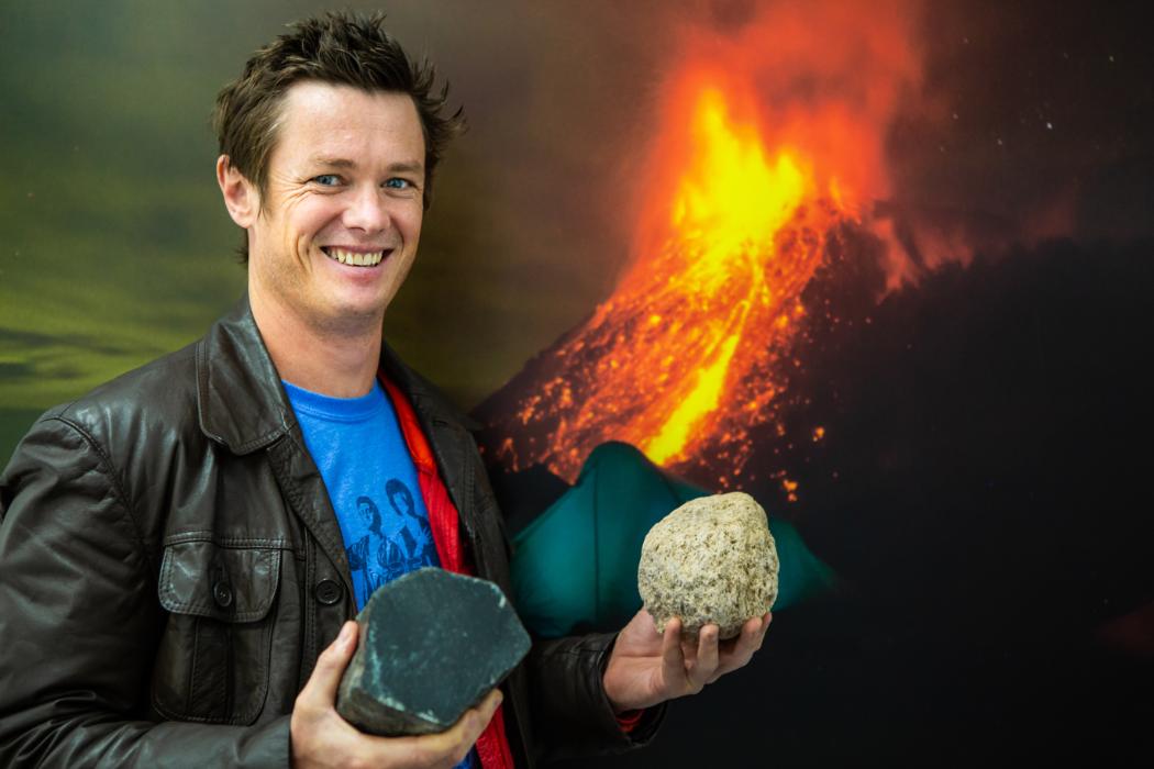Ben Kennedy holding volcanic rock samples.