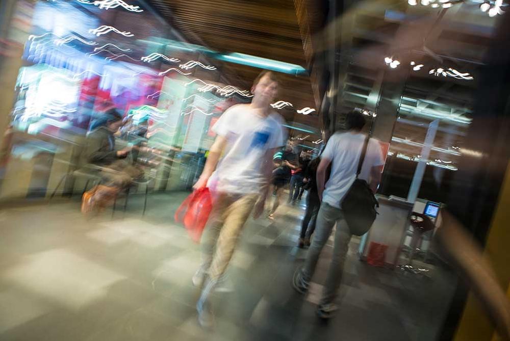 Students walking across the concourse in the Undercroft at the Canterbury University, with a blurred effect.