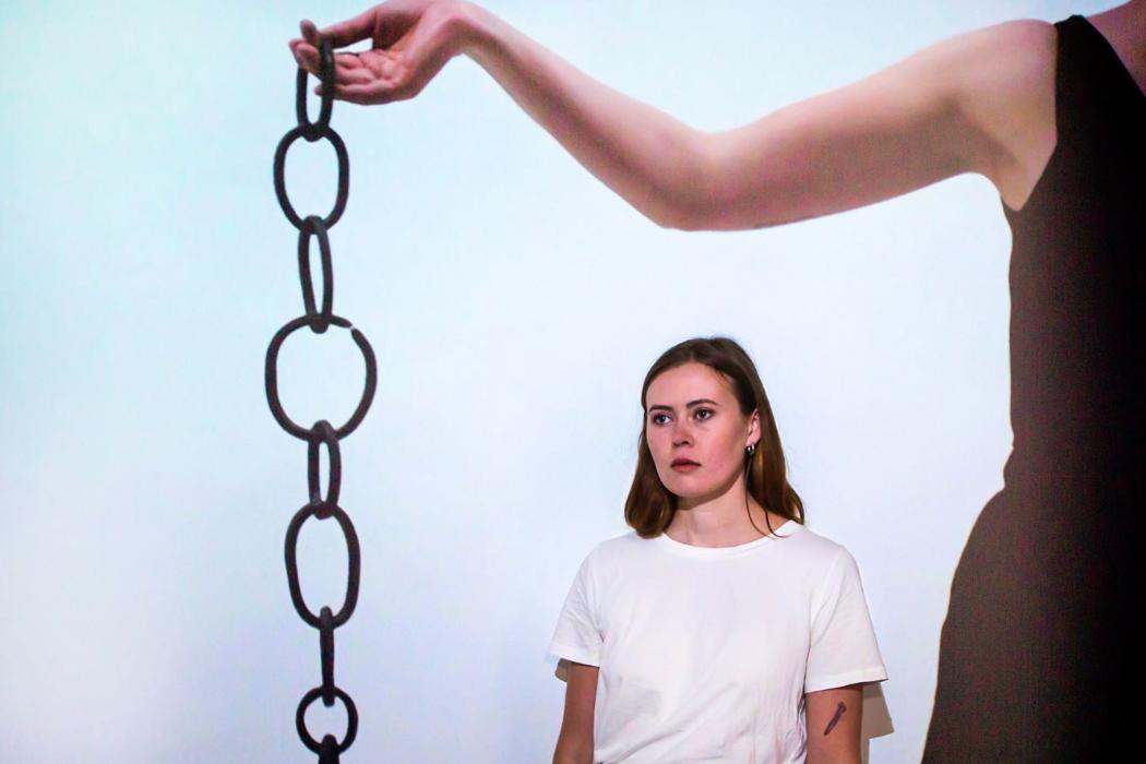 Izzy Wadeson-Lee with if by dull times, our english must be chained, a sculptural installation comprising forged steel chains, draped cloth and video projection.
