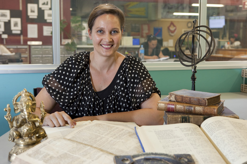 Clemency Montelle sitting at a table covered with rare books.