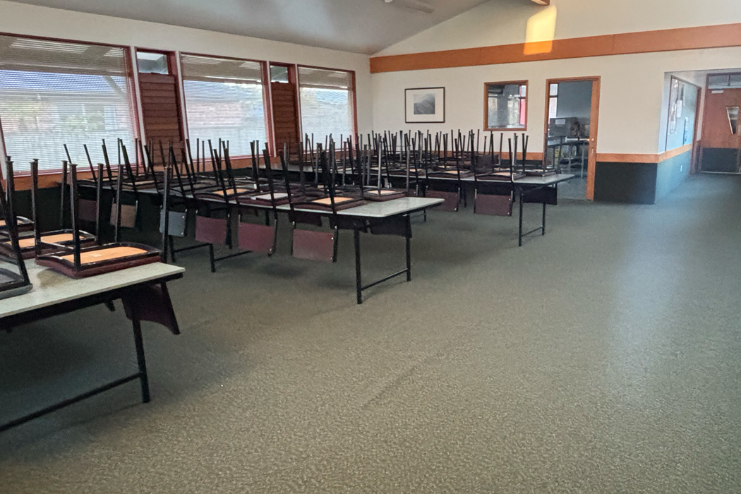 Room the long tables and chairs stacked on top.
