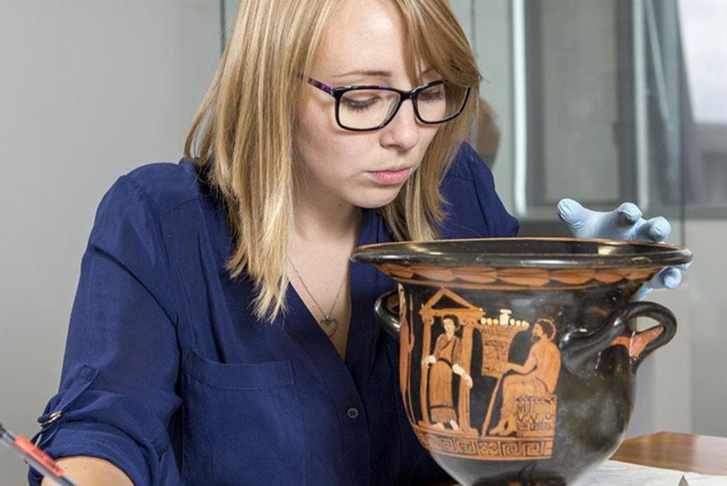 Student examines large ceramic cup