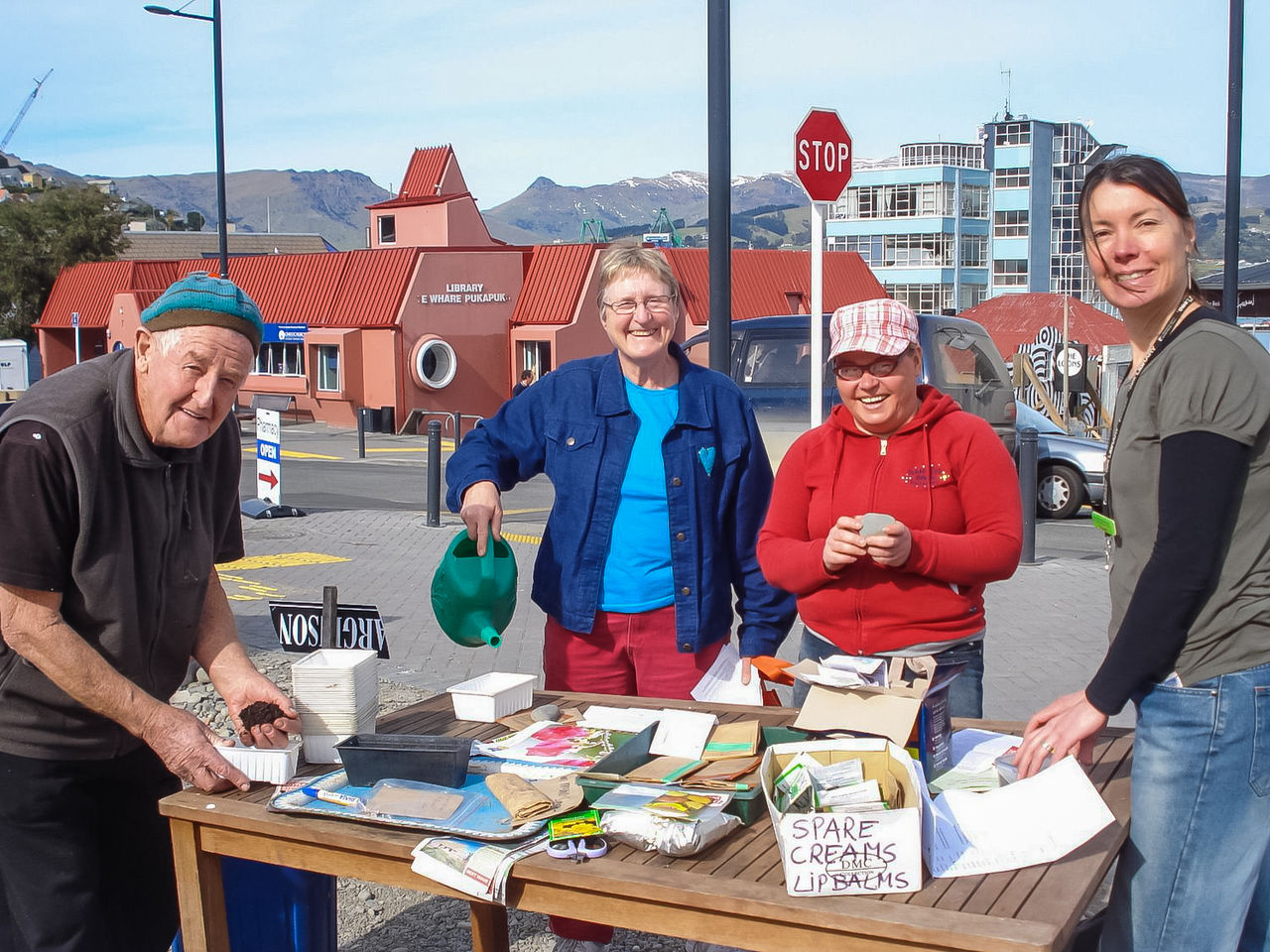 people smiling behind a table with seed packets on it