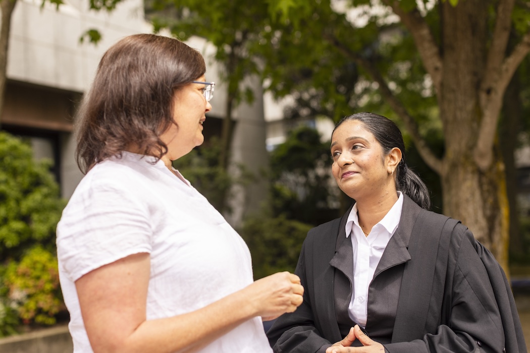 UC Law student and staff member talking