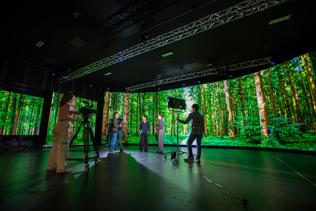 Students filming a scene using the volume at UC's Digital Screen campus.