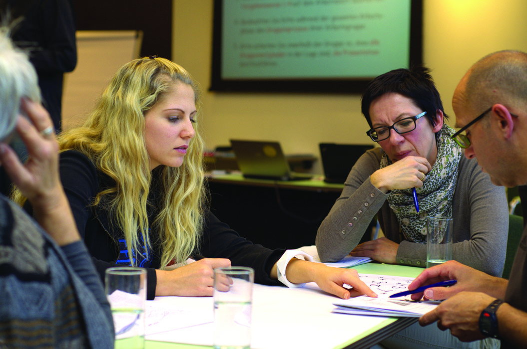 Four people in a meeting going over documents together
