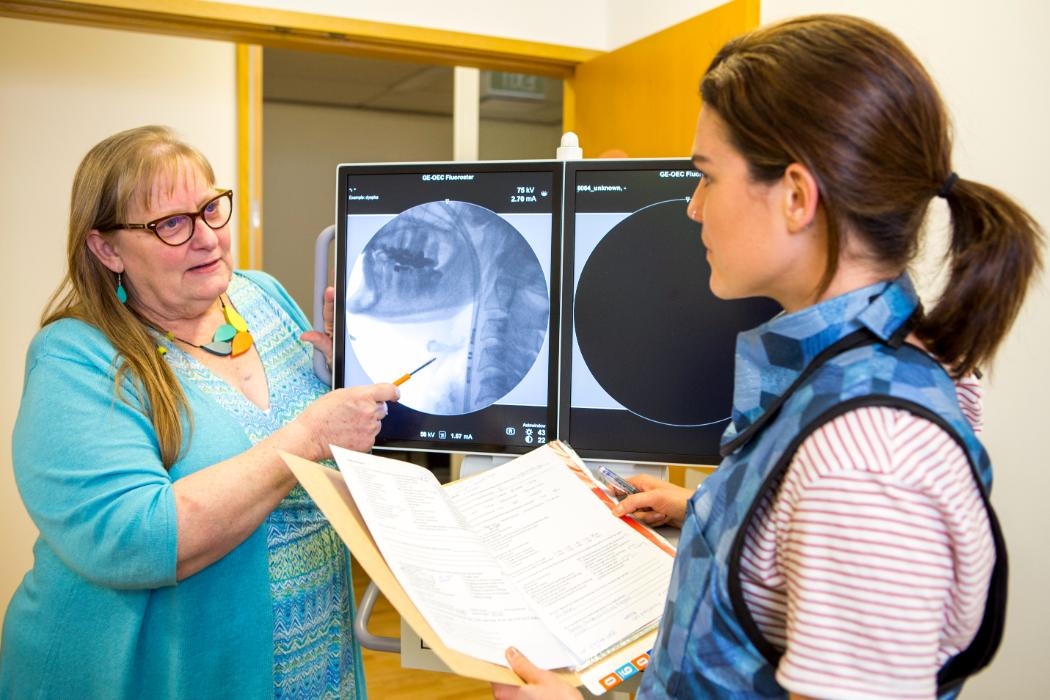 Researcher and postgrad looking at scan of throat on a screen