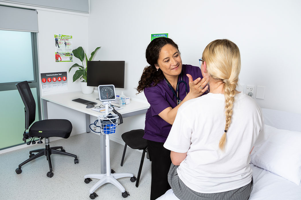 UC Nursing student assessing a patient in a clinic.